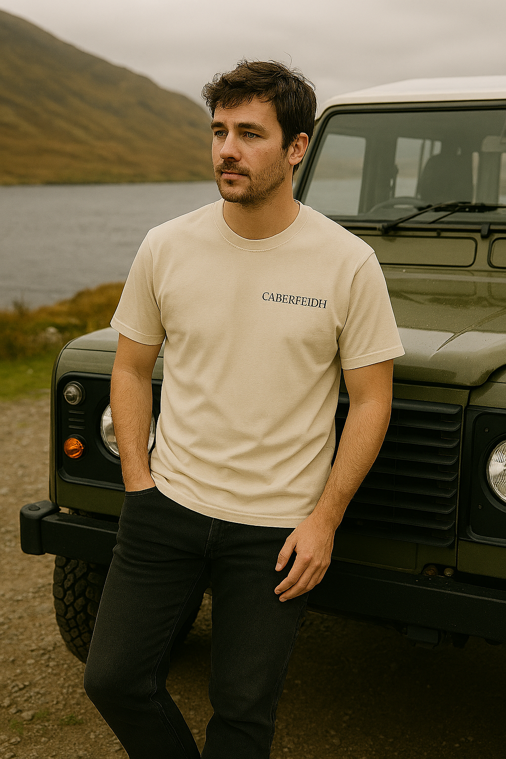 Caberfeidh heritage clothing - model wearing Caberfeidh tee against Highland backdrop with Land Rover Defender